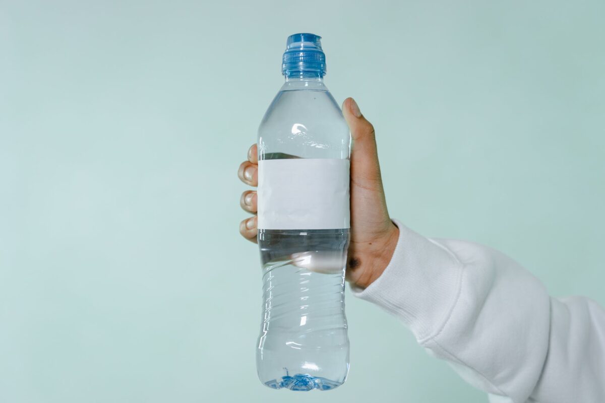 person holding clear plastic bottle